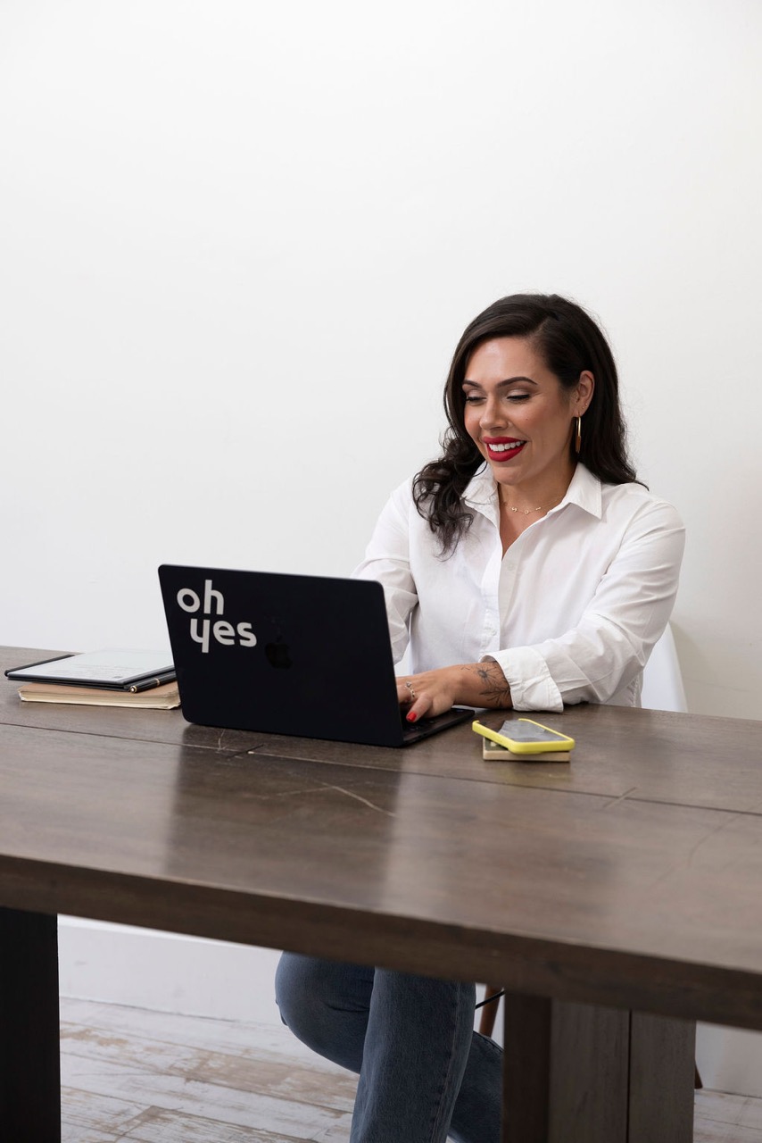 Kathy at her desk with the 'oh yes' laptop